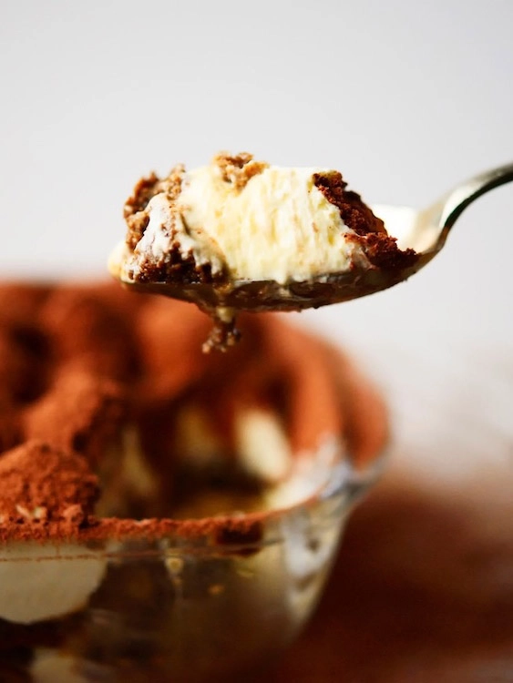 Spoonful of classic homemade Dilettamisù tiramisu with cocoa and cream